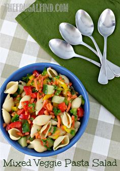 mixed veggie pasta salad in a blue bowl with spoons on the side