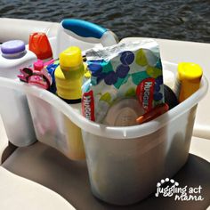 a plastic container filled with baby items sitting on top of a boat