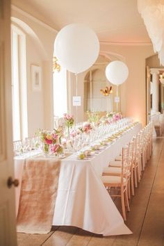 a long table is set with white and pink flowers