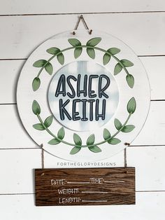 a sign hanging on the side of a white wall that says asher ketth