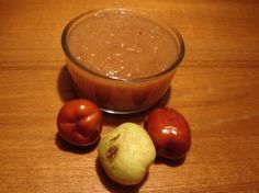 a wooden table topped with a glass bowl filled with fruit