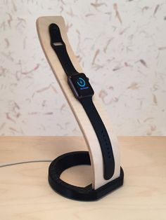 an apple watch charging station on top of a wooden table