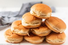 a pile of mini hamburgers sitting on top of each other next to a napkin