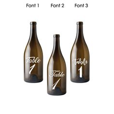 three wine bottles with the names table 1, table 2 and table 4 written on them