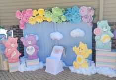 there are many teddy bears on display in front of the wall with clouds and flowers