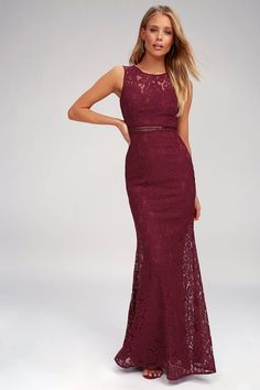 a woman in a long burgundy dress with an open back and lace detailing on the skirt