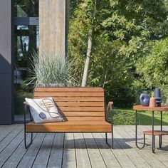 a wooden bench sitting on top of a wooden deck next to a table and chairs