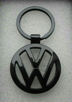 a volkswagen emblem keychain is shown on a white surface