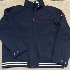 Authentic Tommy Hilfiger Lightweight Water Resistant Regatta Jacket !! . Brand New Never Worn !! And It’s Christmas Time ! . So Here’s The Deal, It’s Brand New, Never Worn With Tags, Dark Blue Majority Color With White Stripes On An Elastic Bottom. Also Has A Velcro Holding Hood (Pictured). Great Buy Being The Time Of Year And The Holidays !! Scoop It Up !!. Be Great For 20-50 Degree Weather. Xxl Size Thanks For Looking!! Blue Tommy Hilfiger Outerwear With Pockets, Casual Navy Windbreaker For Work, Casual Blue Tommy Hilfiger Outerwear, Tommy Hilfiger Jacket Mens, Vintage Tommy Hilfiger Jackets, Yellow Rain Jacket, Tommy Hilfiger Coat, Tommy Hilfiger Long Sleeve, Camouflage Jacket