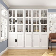 an empty room with white cabinets and chairs