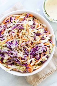 a white bowl filled with coleslaw and dressing