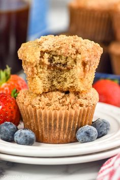 two muffins stacked on top of each other with blueberries and strawberries