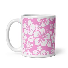 a pink and white coffee mug with flowers on it