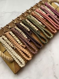 a bunch of different colored cords on a wooden board next to a keychain