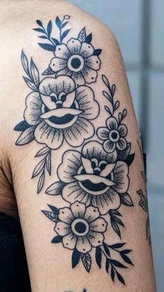 a woman's shoulder with black and white flowers on her left arm, in front of