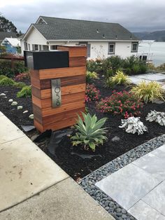 a house with flowers and plants in the front yard, next to it is a phone box