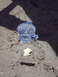 a blue and white glove laying in the sand