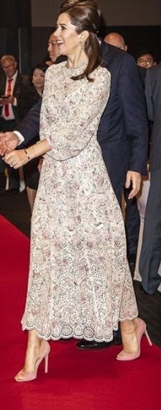 two people shaking hands on a red carpet