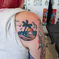 a woman with red hair has a tattoo on her arm and palm trees in the background