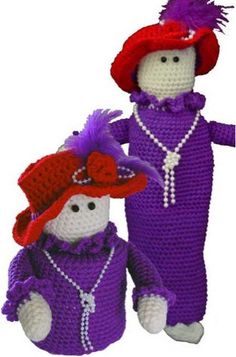 two crocheted dolls dressed in purple and red