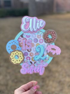 a person holding up a sticker with donuts and letters on it that spell out the word ellie