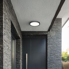 a modern entry way with black doors and brick walls