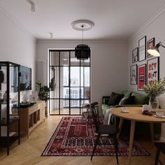 a living room filled with furniture and a large rug on top of a hard wood floor