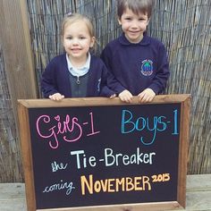 two young children standing behind a sign that says girls i boys the tie - breaker