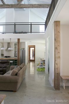 a living room filled with furniture and a kitchen in the backgroung area