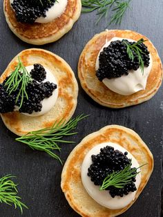 three pancakes topped with black cavia and dill