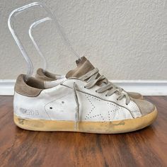 Golden Goose Men's Super-Star W Perforated Star White/Taupe Leather/Suede Us 6 Overall In Great Pre-Loved Condition With Moderate Wear On Upper Material (Creases W Intentional Distressing), Insoles (Footprint Marks), And Outsoles (Heel Drags). See All Pictures For Detail. Elevate Your Shoe Game With These Designer Golden Goose Super-Star Sneakers. Crafted In Italy From High-Quality Leather And Suede, These Shoes Feature A White And Taupe Perforated Star Pattern That Adds A Unique Touch To Any Outfit. The Adjustable Strap And Lace-Up Closure Ensure A Secure And Comfortable Fit, While The Rubber Outsole Provides Durability For All Seasons. These Shoes Are Perfect For Both Casual And Activewe Shoes Golden Goose, Goose Shoes, Taupe Leather, Golden Goose Shoes, Star Sneakers, Star Pattern, Super Star, Sneaker Collection, Golden Goose