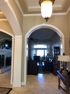 an archway leading to a living room and dining room area in a house with beige walls