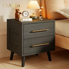 a night stand with two drawers and a clock on it next to a bed in a bedroom