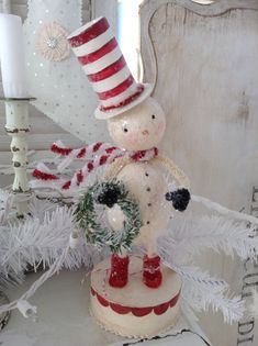 a snowman with a wreath on top of it