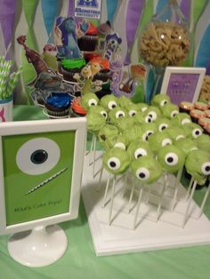 a table topped with lots of cupcakes covered in green frosting