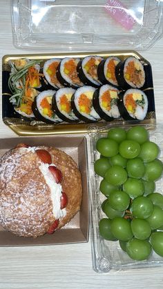 an assortment of sushi and grapes on a table