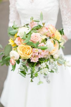 a bridal holding a bouquet of flowers and greenery