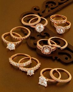 six different types of rings on a brown surface with a black and white key in the background