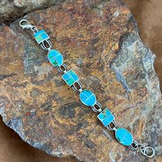 This beautiful Sterling Silver Bracelet showcases the spectacular Green, Blue and Yellow hues of Sonoran Gold Turquoise from Mexico. Total Length of Link Bracelet 6 1/2" Dimensions: Link width 7/16" -- Total of 6 Links They are designed by David Rosales, one of the finest contemporary Southwest Artists in the world. He is the founder and co-owner of Supersmiths, Inc. of Gallup, NM. Each Handcrafted Bracelet is custom made and carries a lifetime guarantee. Elegant Turquoise Bracelet With Inlay, Elegant Turquoise Inlay Bracelet, Blue Inlay Bracelet Jewelry, Blue Inlay Bracelet, Southwestern Style Blue Inlay Bracelets, Artisan Turquoise Bracelet With Inlay, Southwestern Blue Oval Bracelets, Artisan Turquoise Bracelets With Inlay, Bohemian Blue Bracelets With Inlay