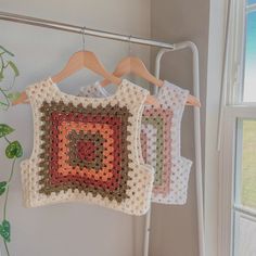 three crocheted squares hanging on a clothes rack