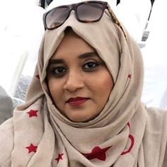 a woman wearing sunglasses and a scarf with stars on it is looking at the camera