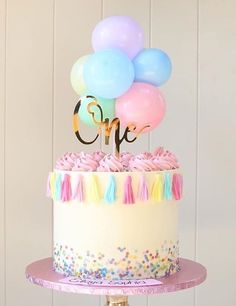 there is a cake with balloons on top