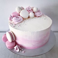 a white cake with pink frosting and decorations