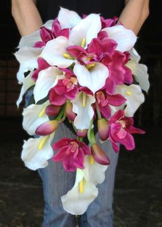 a bouquet of white and pink flowers in someone's jeans, holding it up