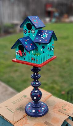 a blue birdhouse sitting on top of a wooden table