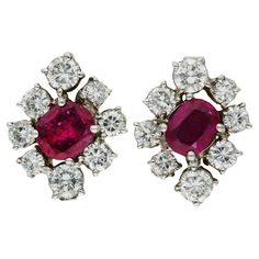 Certified 14ct White Gold 2.4ct Diamond & 1.4ct Ruby Earrings Enhance your fashion ensemble with our Pair of Pre-Owned 14ct White Gold Ruby & Diamond Cluster Earrings, an exquisite testament to luxury and style. Central to each earring is a striking oval-cut ruby, surrounded by a dazzling halo of round brilliant-cut diamonds of varying sizes. The deep red shade of the rubies radiates warmth and charm, while the glittering diamonds introduce a layer of sparkling allure. The distinct design and careful placement of the gemstones offer a sophisticated and captivating appearance. Expertly crafted in gleaming 14ct white gold, these earrings demonstrate exceptional skill and enduring elegance. Perfect for special events or adding a glamorous touch to everyday attire, these Pre-Owned 14ct White G Ruby Jewellery, Round Diamond Earrings, Vintage Stud Earrings, Diamond Earrings Studs Round, Diamond Cluster Earrings, Ruby Earrings, Ruby Jewelry, Round Stud Earrings, Antique Earrings