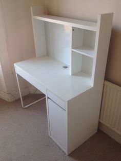 a white desk with an open shelf on top