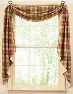 a window with plaid curtains in front of it and a cat sitting on the windowsill