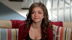 a young woman sitting on top of a couch