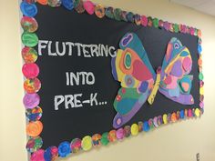 a bulletin board with colorful paper flowers and butterflies on it that says, fluttering into prek